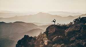 A ballet dancer stretching surrounded by mountains
