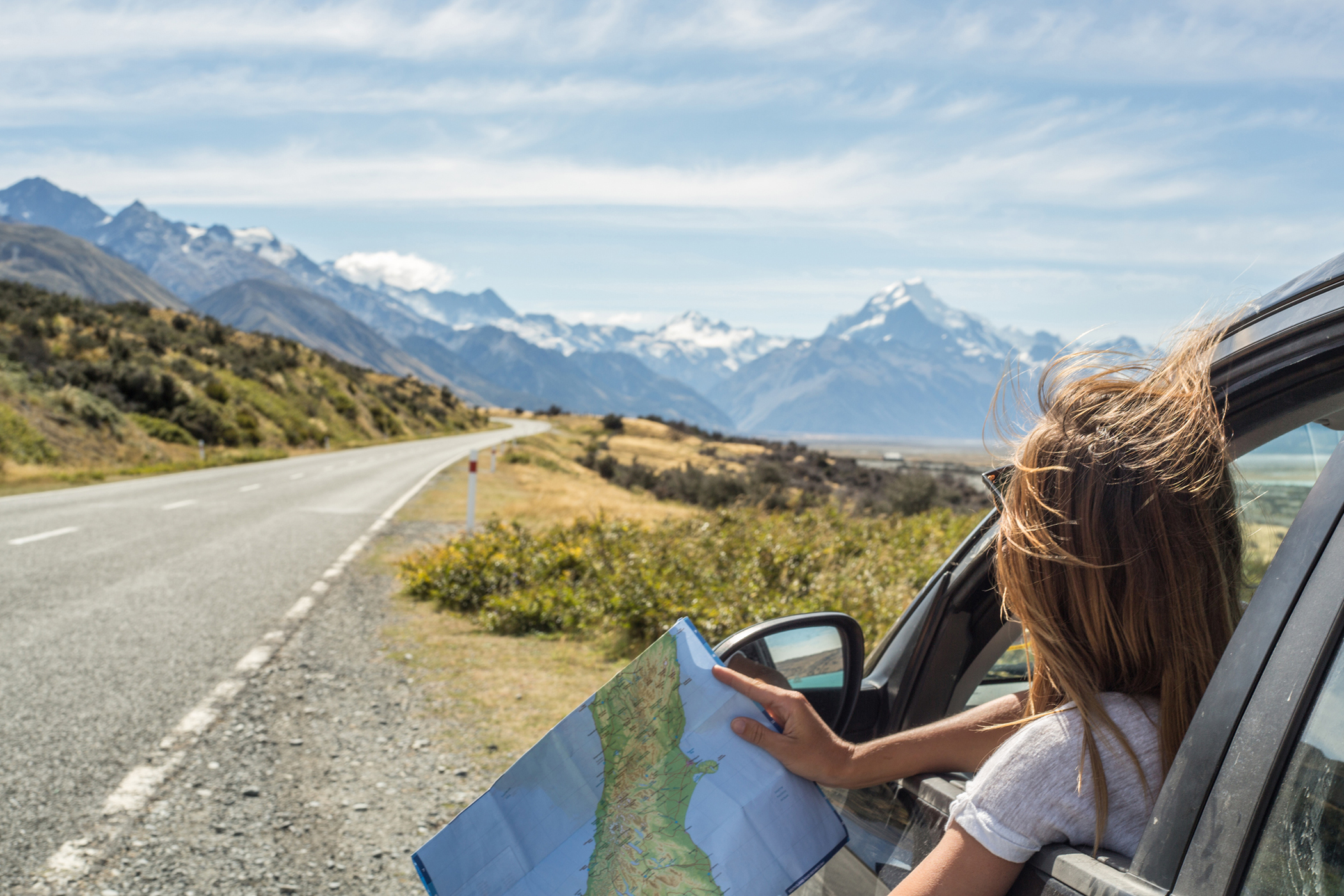 Woman travelling by car holding a map